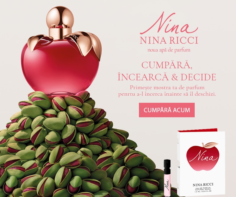 Sticlă de parfum Nina Ricci Nina, roșie, așezată pe un morman de fistic, alături de ambalajul produsului.