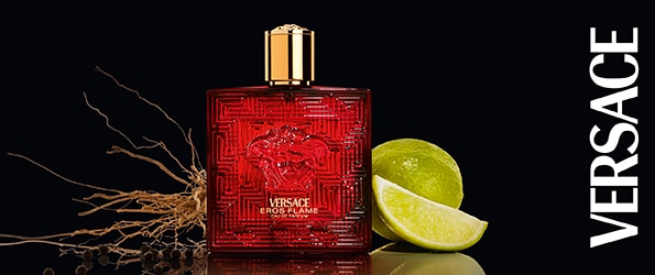 Parfum Versace Eros Flame în sticlă roșie elegantă, alături de lime proaspăt și rădăcini aromatice – parfum de lux pentru bărbați.